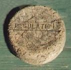 A worn, dark rubber puck photographed against a plain background.