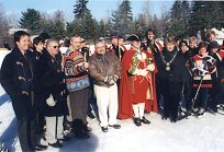 A crowd gathered on and around the frozen pond on a bright winter day.