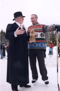 Two men on the ice with arms raised, snow underfoot.